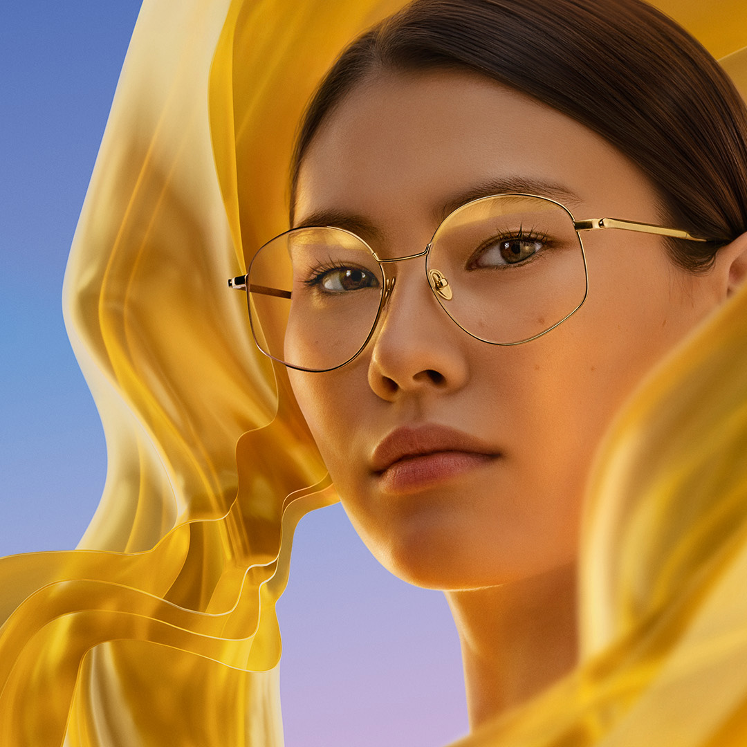 Жінка в окулярах із лінзами з антивідблисковим покриттям ZEISS DuraVision Gold UV, що надає лінзам ледь помітного золотистого блиску.