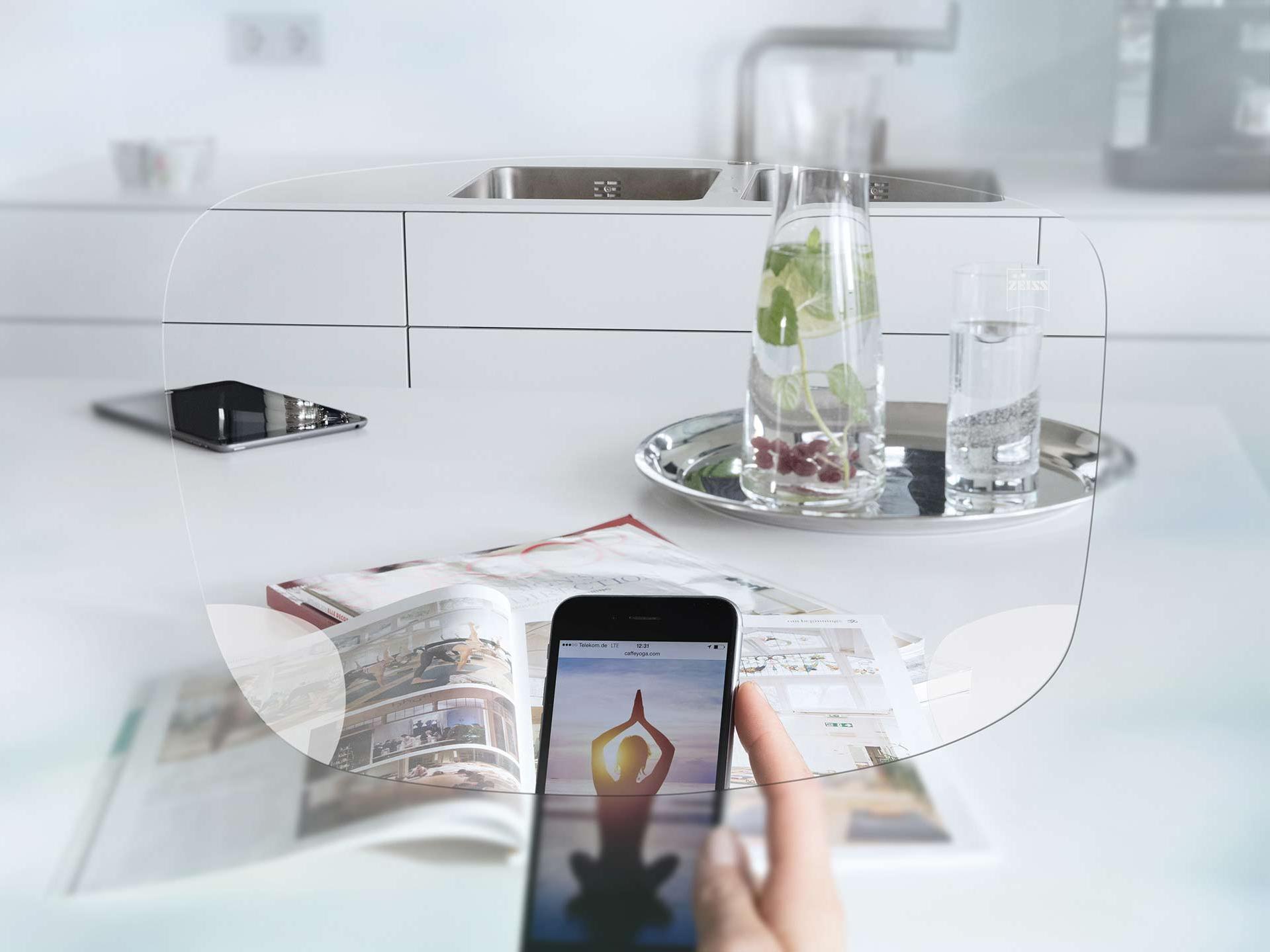 Вид на екран смартфона та сервірований кухонний стіл крізь монофокальні лінзи для окулярів ZEISS EnergizeMe