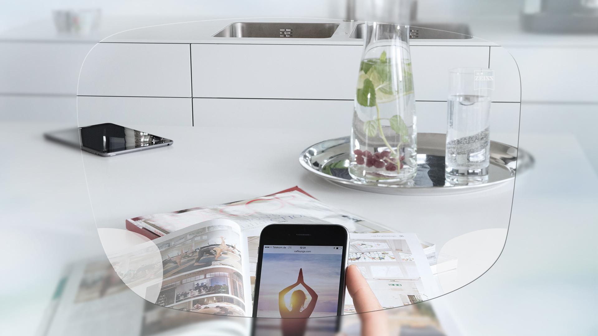 Вид на екран смартфона та кухонний стіл крізь монофокальні окулярні лінзи ZEISS EnergizeMe