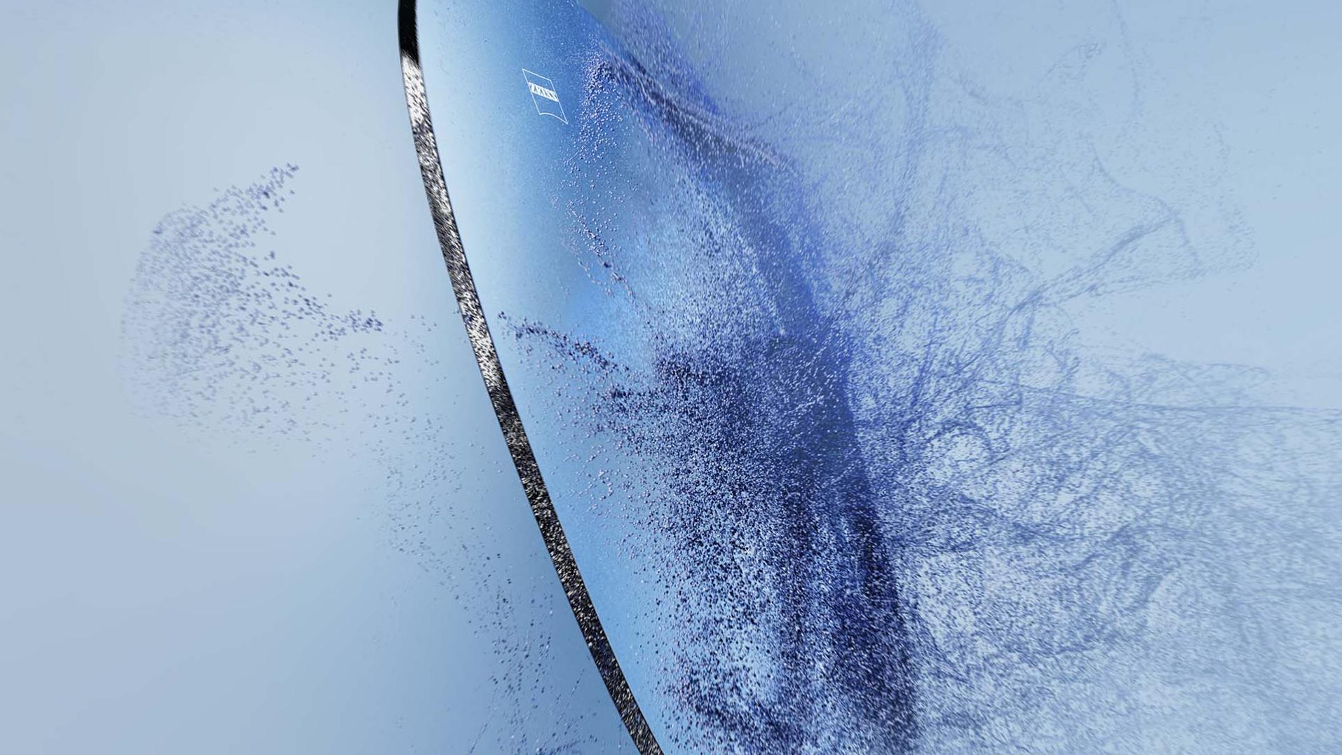 Лінза для окулярів із логотипом ZEISS торкається піску.