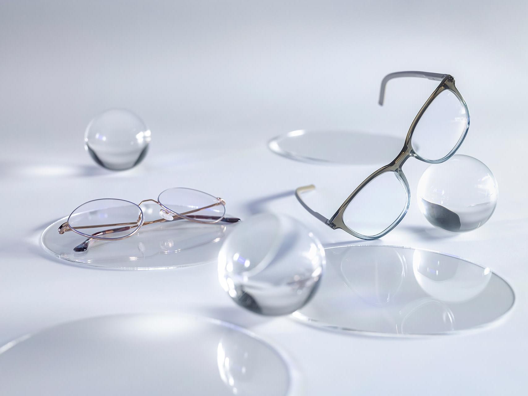 Окуляри з лінзами ZEISS із нанесеним покриттям DuraVision® Silver практично без відблисків порівняно з розташованими поряд скляними сферами.
