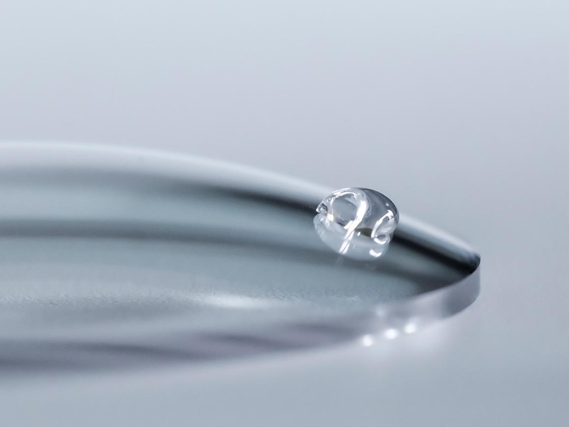 Крапля води зісковзує з лінзи ZEISS із покриттям, яке полегшує очищення.