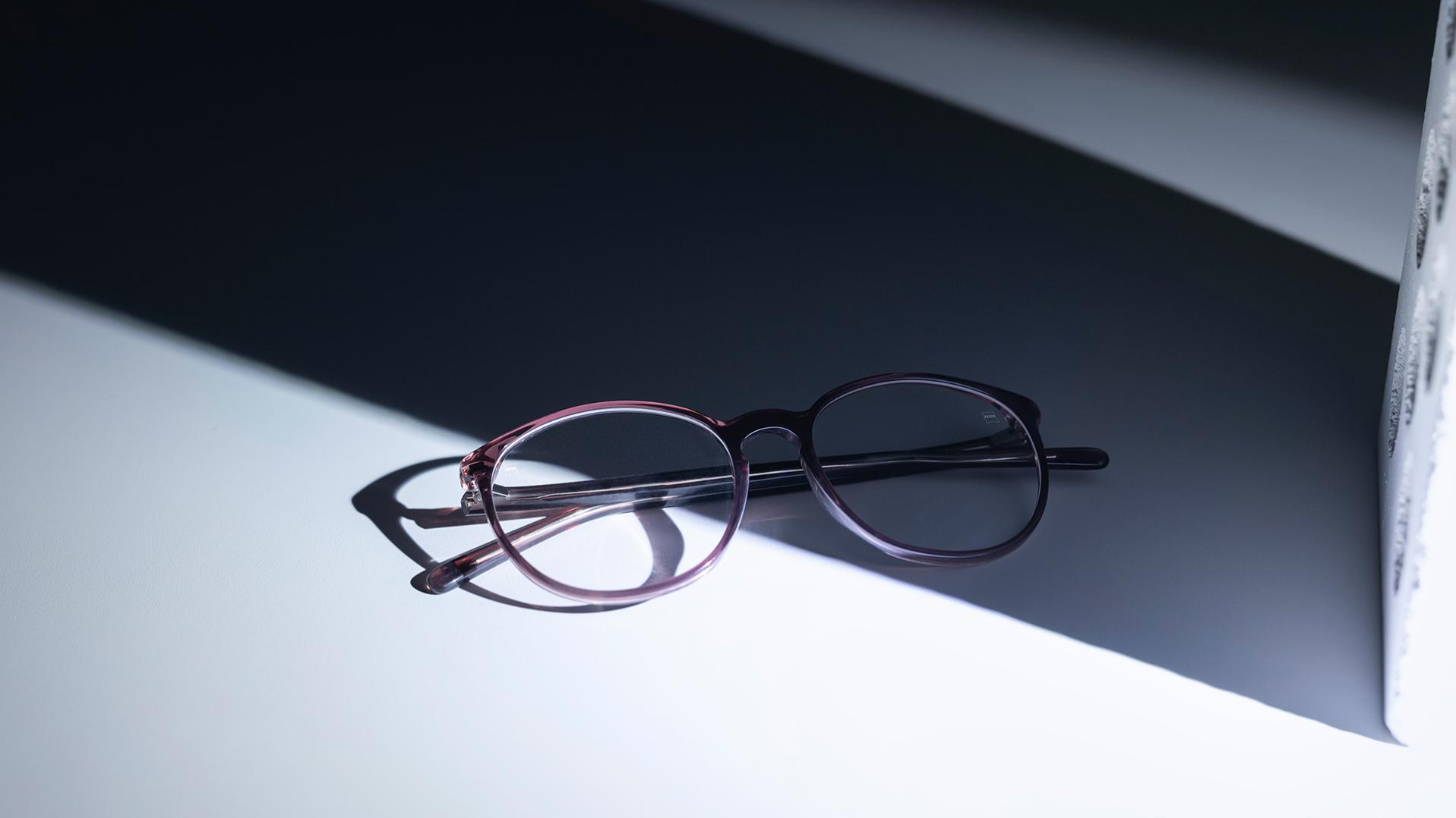 Окуляри з лінзами ZEISS та покриттям DuraVision® лежать наполовину в тіні, наполовину на сонці.