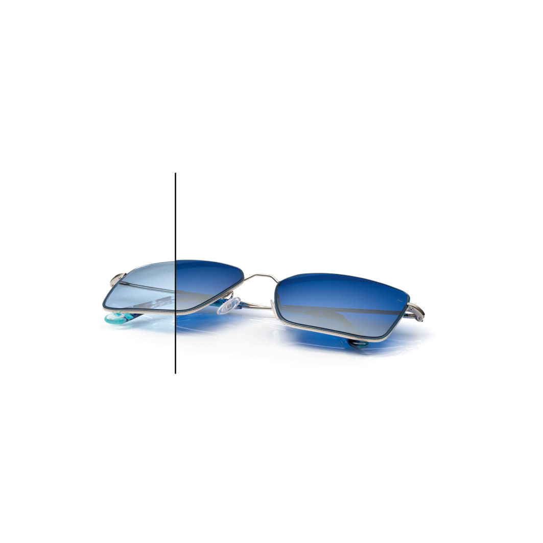 Окуляри з лінзами ZEISS PhotoFusion X синього кольору з дзеркальним покриттям ZEISS DuraVision Flash кольору Diamond. Половина лінзи затемнена неповністю, щоб показати різницю в кольорі.
