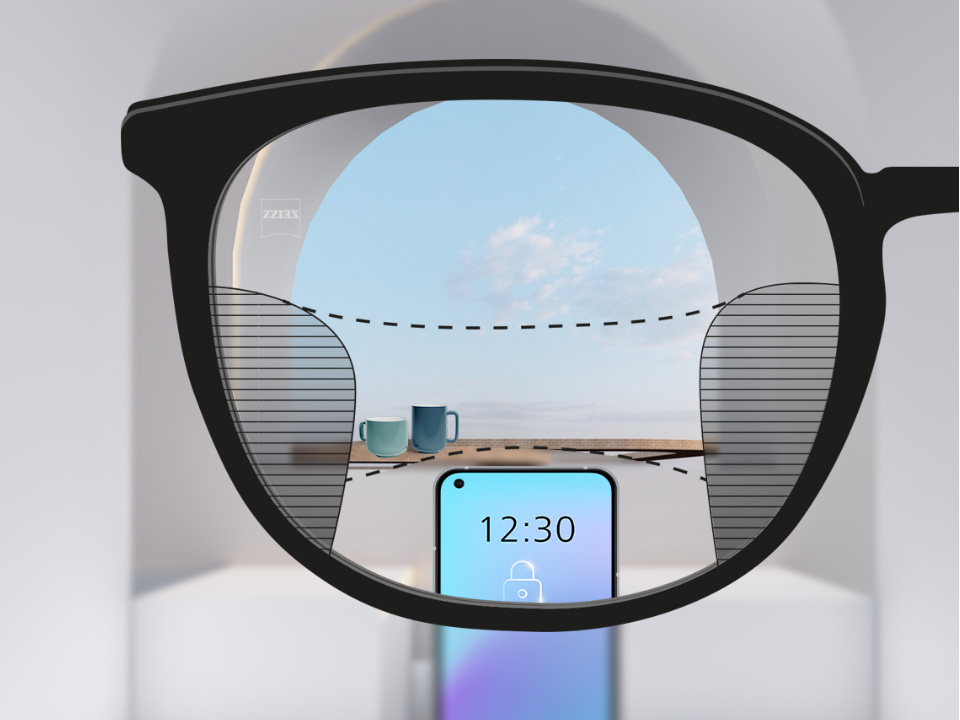 Зображення при погляді крізь лінзи ZEISS Progressive SmartLife зі смартфоном і чашками на фоні; зображення повністю чітке по всій лінзі з вузькими смугами розмитості зліва та справа.
